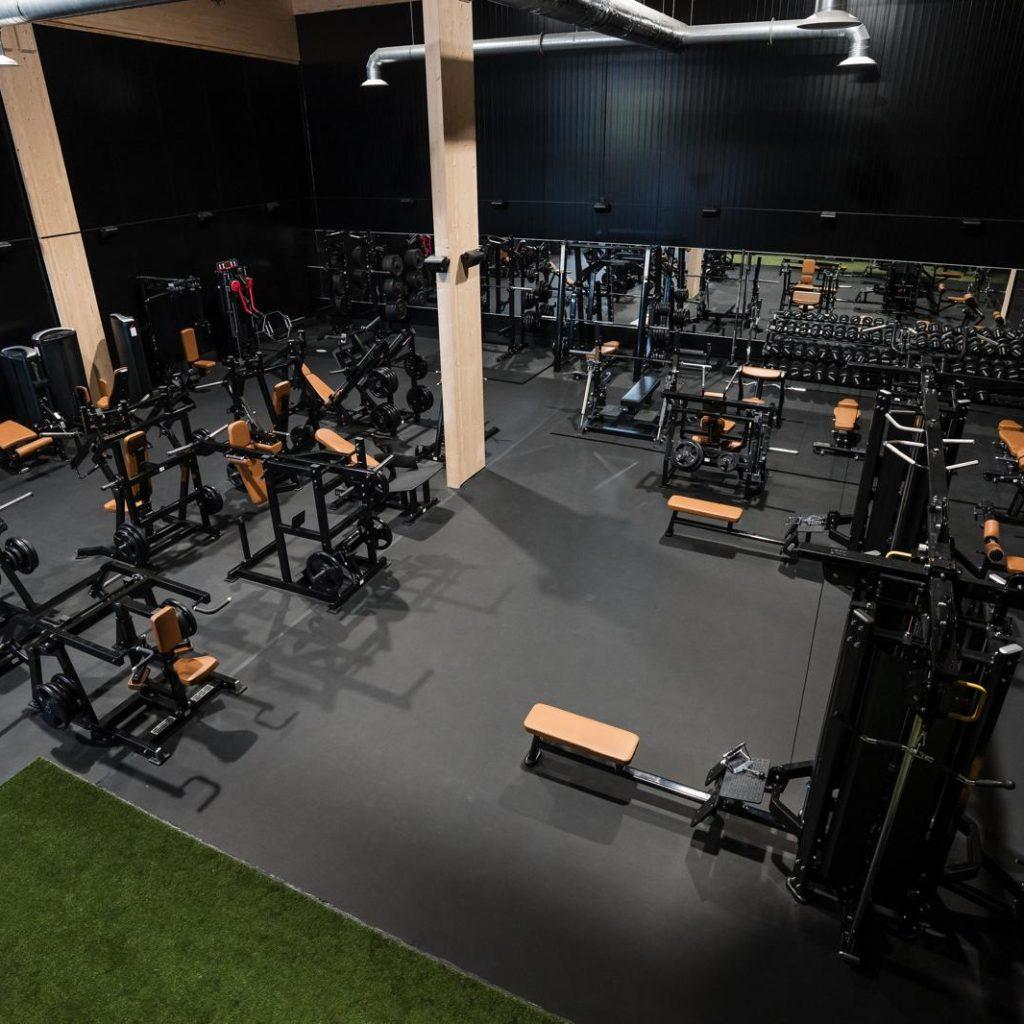 Yrittäjä seisoo kuntosalilaitteiden keskellä Gym Productions Finlandin toimitiloissa Heinolassa