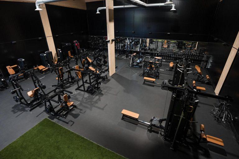 Yrittäjä seisoo kuntosalilaitteiden keskellä Gym Productions Finlandin toimitiloissa Heinolassa